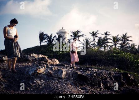 Two women walking on rocky shoreline on the coast at Toco, Trinidad c 1963 Stock Photo