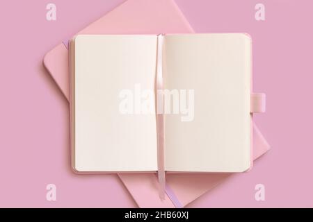Opened pink notebook on on other one on light pink table top view. Textbook mockup, planner cover with place fot text. Educational, business and organ Stock Photo