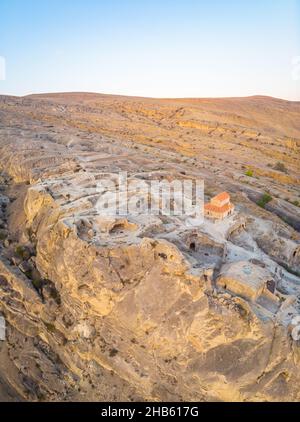 Aerial close up view  to Uplistsikhe cave town with  basilica in the middle and vulcanic rock formations around. Sighseeing and travel in Georgia. Stock Photo