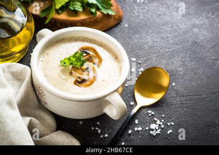 Mushroom Soup in craft bowl on dark stone table. Stock Photo