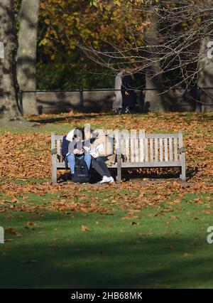 London, England, UK. Young couple on a park bench in St James's Park, December 2021 Stock Photo