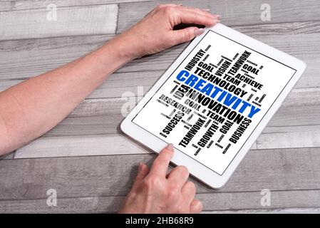 Creativity word cloud concept shown on a tablet used by a woman Stock Photo