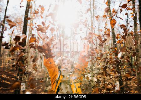 Two senior female friends hiking together through the forest in autumn Stock Photo