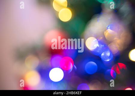 Colored Christmas lights. Defocused background. Christmas tree with balloons and garlands. Stock Photo