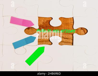 Hand writing sign Public Relations. Word Written on practice managing spread of information between individual Building An Unfinished White Jigsaw Stock Photo