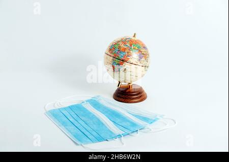 Surgical Face Mask and Globe model. Coronavirus Concept. Medical Face Mask For Stopping The Spread of Flu Virus. Stock Photo