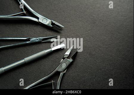 Set of manicure scissors, clipper, spatula, for nail care on a black background. Professional pedicure equipment for masters, beauty salons or home us Stock Photo