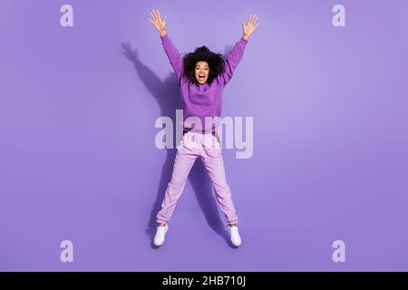 Full size portrait of pretty cheerful lady overjoyed raise hands good mood isolate don violet color background Stock Photo