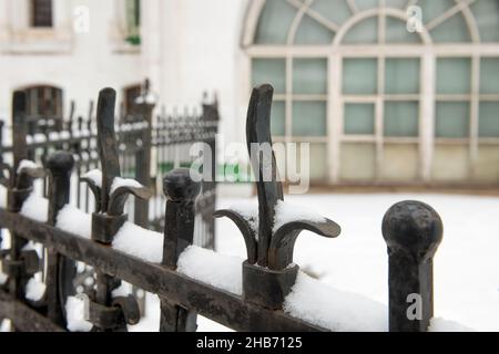 Forged metal fence covered with snow on a winter day Stock Photo