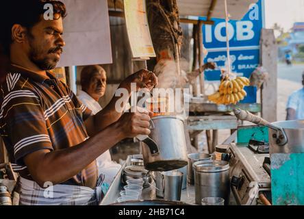 Tamil Nadu, India - January 14, 2016. A man prepares a pot of chai tea at a roadside food stand in early morning light. Stock Photo