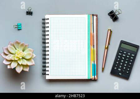 open notepad, calculator, golden pen, home plant on gray background spiral notebook on table Business, planning, education, morning life working from Stock Photo