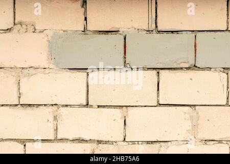Wall of bricks painted with a pale peach paint Texture of masonry Beautiful blank background. Stock Photo