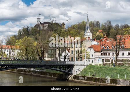 Ljubljana, Slovenia - 04 13 2018: Bridge and the  banks of the river with the city monuments in the background Stock Photo