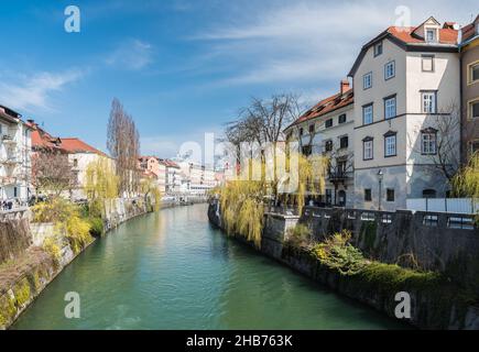 Ljubljana, Slovenia - 04 13 2018 View over the Ljubljana river with young people sitting at the banks Stock Photo