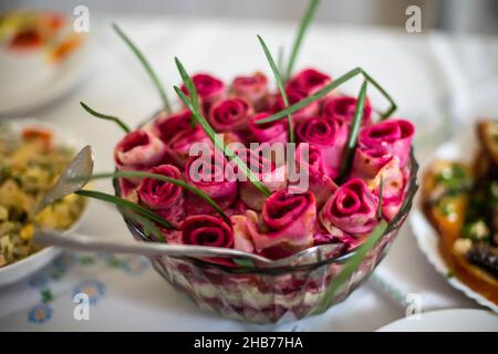 Herring under a fur coat salad, shuba on holiday table. Layered salad with herring, beets, potatoes, carrots, onions and eggs. Originally decorated wi Stock Photo