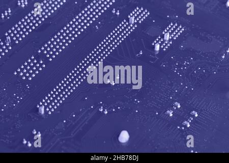 Defocused trendy very peri color concept of the year 2022, violet blue, lavender computer motherboard closeup background. Selective focus Stock Photo