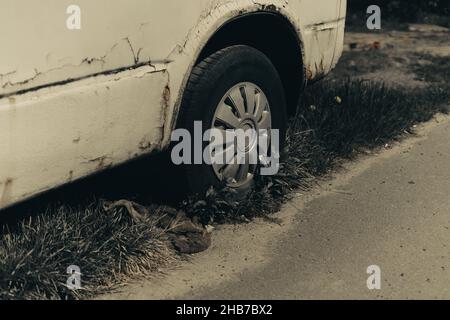 Old rusty car wheel. Cracked tires and a rusted hubcaps. Stock Photo
