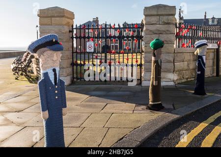 The war memorial at Redheugh Gardens,Hartlepool Headland, England,UK. Poppies on the railings and woollen Forces figures Stock Photo
