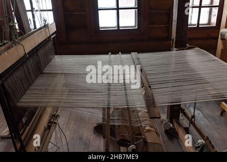 Antique weaving loom with threads in folk crafts museum Stock Photo