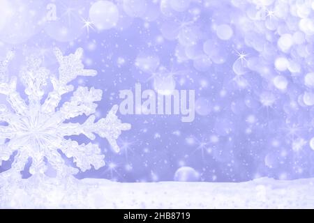 Christmas background with soft focus. Big transparent snowflake in snow and beautiful bokeh with asterisks and snowfall in color of 2022 year Very Per Stock Photo