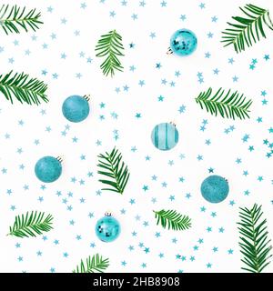 Christmas pattern with evergreen tree branches and red decoration on white background. Flat lay, top view Stock Photo