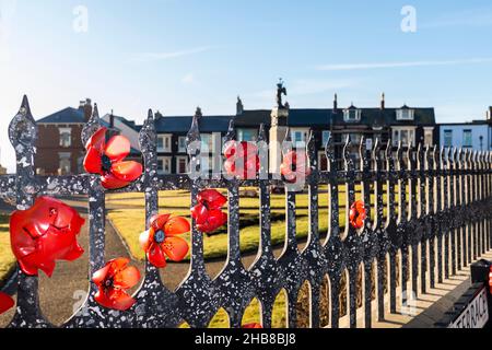 The war memorial at Redheugh Gardens,Hartlepool Headland on the north east coast of England,UK. Poppies on the railings Stock Photo