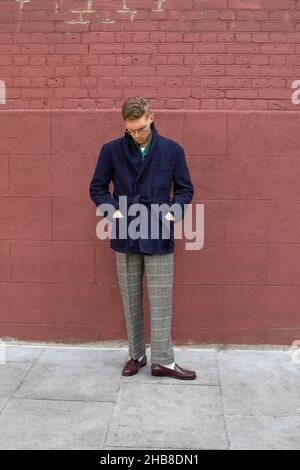 Young man wearing winter clothes in the street. Young guy with penny loafer and stylish over coat Stock Photo