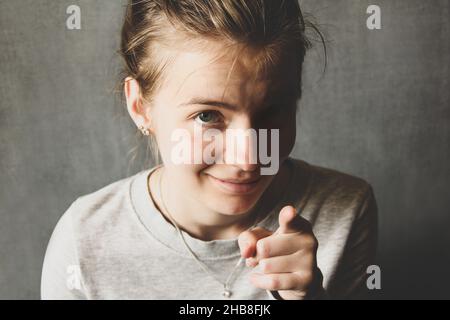 The girl looks at the camera and shows her finger. Emotional girl. Facial emotions Stock Photo