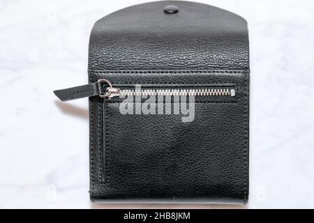 Top view of black genuine leather wallet with banknotes and credit card inside isolated on white background. Stock Photo