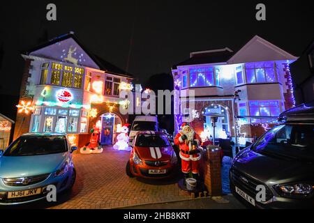 Poole, Dorset, UK.  17th December 2021.  Britain’s most festive street at Runton Road in Poole, Dorset where most of the houses are decorated in colourful Christmas lights for charity.  The illuminated Christmas displays have been organised by the residents for approximately twenty years and raises funds for local charities from donations made by the many visitors.  Picture Credit: Graham Hunt/Alamy Live News Stock Photo