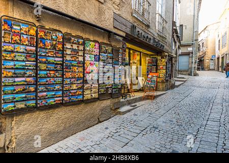 A postcard shop on Rue Cros Mayrevieille in the Cité de Carcassonne, Aude department, France, displays its stock on wall-mounted racks, with a cobbled lane in front. Stock Photo