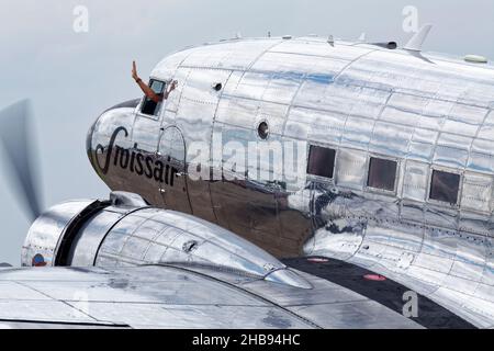 Close up of a Swiss air Douglas DC-3 Dakota with pilot waving out of the the cockpit. Stock Photo