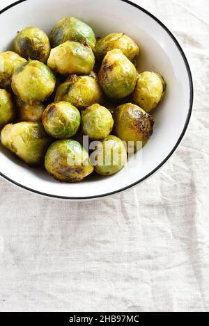 Roasted brussles sprouts in bowl over light background with free text space. Stock Photo
