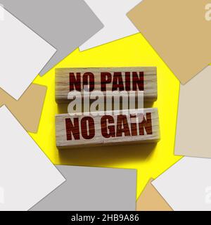 No Pain No Gain message written with wooden blocks on yellow. Business success concept. Stock Photo