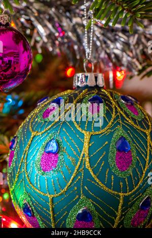 large christmas bauble hanging decoration on a christmas tree, decorative glass bauble hanging on festive christmas seasonal tree, glass decorations. Stock Photo