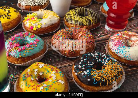 Top view of donuts in various colors and flavors on wooden table Stock Photo