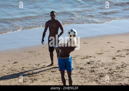 Young people playing sand football on the beach of Ondina in the afternoon sun. Salvador Bahia Brazil. Stock Photo