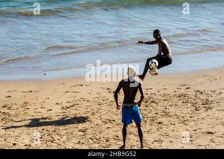 Young people playing sand football on the beach of Ondina in the afternoon sun. Salvador Bahia Brazil. Stock Photo