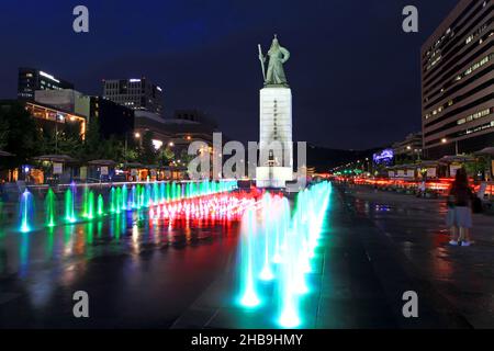 The bronze statue of Admiral Yi Sun Shin in Sejongno, Seoul at blue hour with the colourful water fountain in the foreground. Stock Photo