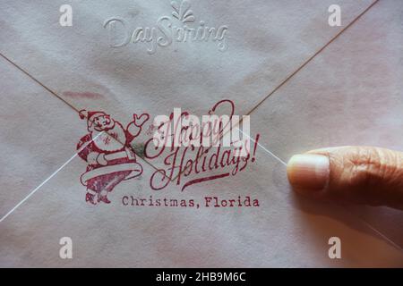 Orlando, United States. 17th Dec, 2021. In this photo illustration, a Christmas card is seen in Orlando, bearing a rubber stamped message from the nearby Christmas, Florida post office. Each year, thousands of people bring their holiday greeting cards to the tiny post office in Christmas, Florida to have them stamped with the unique Christmas postmark and also have their envelopes adorned with seasonal designs and greetings. Credit: SOPA Images Limited/Alamy Live News Stock Photo