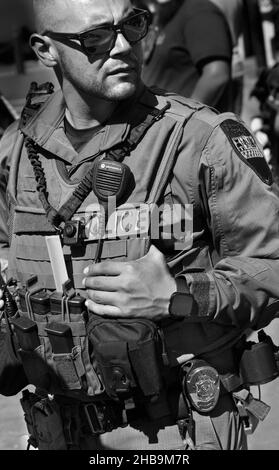 A member of the Santa Fe, New Mexico, SWAT team keeps on eye on the crowd enjoying an outdoor public event. Stock Photo