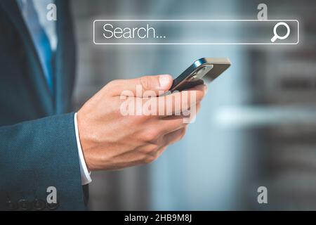 Man searching browsing internet data information in mobile smartphone. Businessman clicking internet search bar. Online search. Networking concept Stock Photo
