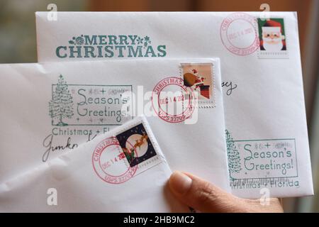 Orlando, United States. 17th Dec, 2021. In this photo illustration, Christmas cards are seen in Orlando, bearing postmarks from the nearby Christmas, Florida post office. Each year, thousands of people bring their holiday greeting cards to the tiny post office in Christmas, Florida to have them stamped with the unique Christmas postmark. Postal customers can also use rubber stamps provided by the post office to adorn their envelopes with seasonal designs and greetings. (Photo by Paul Hennessy/SOPA Images/Sipa USA) Credit: Sipa USA/Alamy Live News Stock Photo