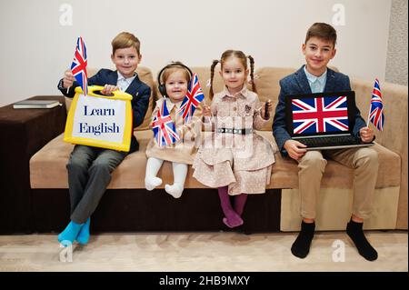 Four kids show inscription learn english. Foreign language learning concept. Stock Photo