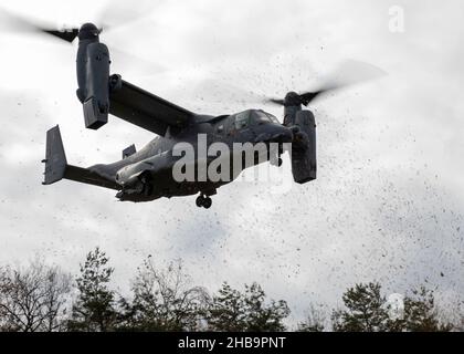 A CV-22B Osprey from the 21st Special Operations Squadron flies low over the trees as it prepares to land during exercise Resolute Dragon 21 at the Ojojihara Training Area, Japan, Dec. 9, 2021. The 21st SOS is specialized in the use of the CV-22B Osprey in conducting long-range infiltration, exfiltration and resupply missions for special operations forces. The CV-22B is equipped with integrated threat countermeasures, terrain-following radar, infrared sensors and other advanced avionics that make it a formidable power projection tool in adverse conditions and contested environments. (U.S. Air