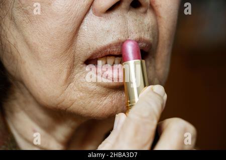 Elderly asian woman applied lipstick Stock Photo
