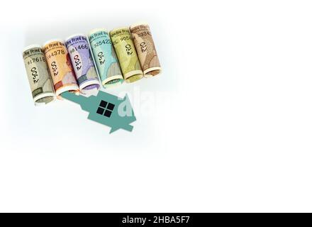 Indian currency notes with 2D paper model home with key, Save money for Future home plan, Real estate business concept Stock Photo