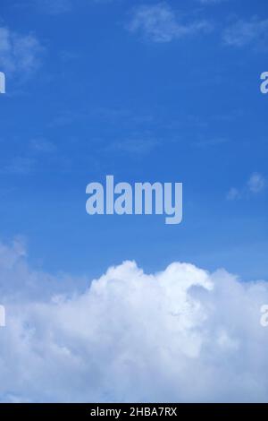 White cumulus clouds on bright blue sky Stock Photo