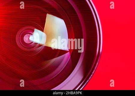 The camera lens and the beautiful light red color. The red rays of refraction on the lens. Optics. Stock Photo