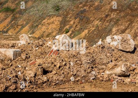 Soil and debris piled up in a heap, discarded concrete blocks Stock Photo